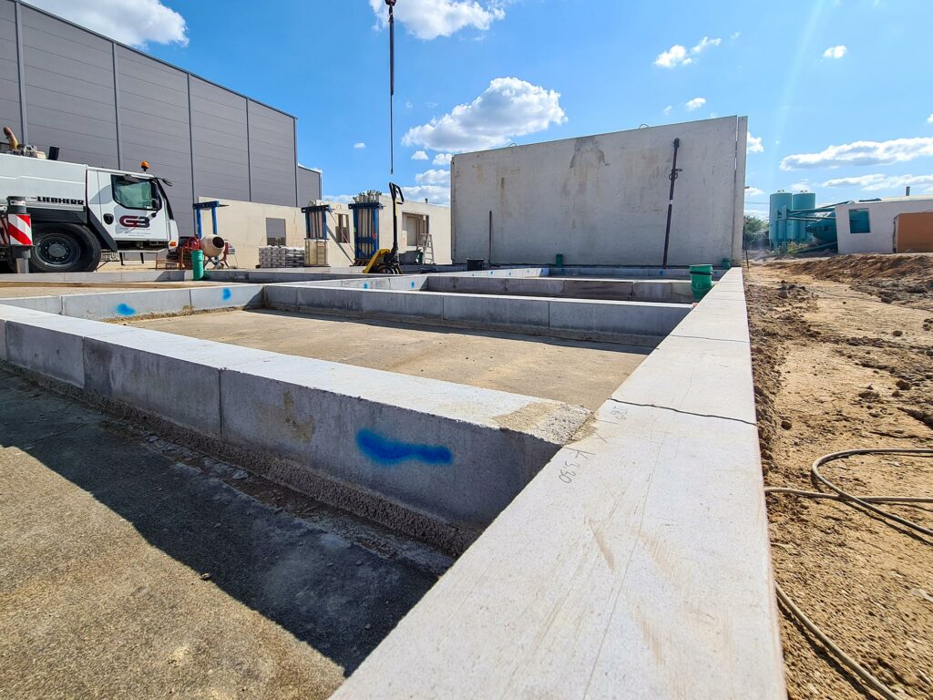 Fertig gelegte Kimmsteine und Stellen der ersten Wände für ein Bürogebäude