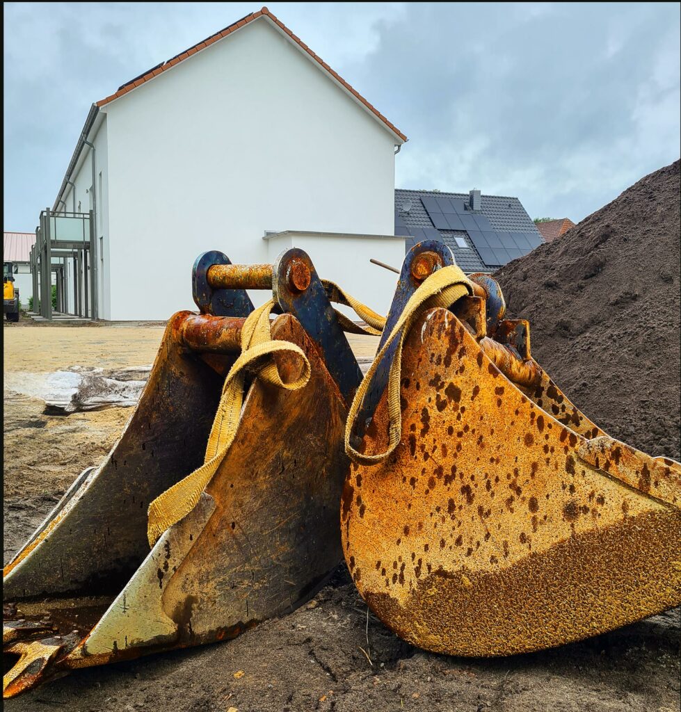 Baggerschaufeln vor einem Mehrfamilienhaus
